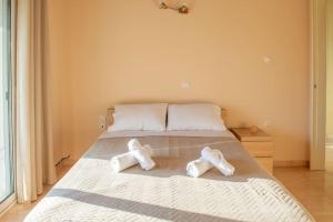 a bed with two white towels on it at Villa Oasis Kato Alepochori in Kato Alepochori