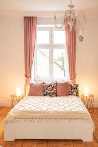 1 dormitorio con cama y ventana grande en Kobieciarnia, en Tczew