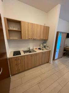 a kitchen with wooden cabinets and a sink in a room at Apart Swinoujscie in Świnoujście