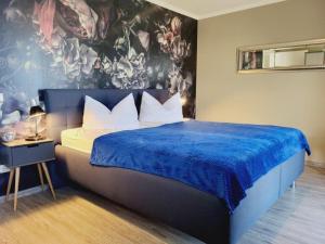 ein Schlafzimmer mit einem großen Bett mit einer blauen Decke in der Unterkunft Appartementanlage Ostseeblick in Kühlungsborn