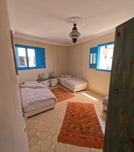 een slaapkamer met 2 bedden en een tapijt bij Taghazout Ocean View in Taghazout