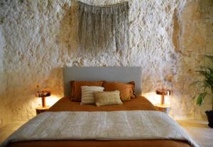 une chambre avec un grand lit avec deux lampes dans l'établissement Les Troglos de la Tufolière, à Rochecorbon