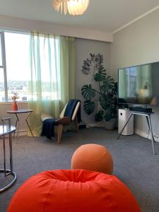 ein Wohnzimmer mit einem großen TV und Möbeln in der Unterkunft Central Nest- view & style in Wellington
