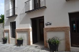 un edificio bianco con piante in vaso di fronte ad esso di Hotel La Vera Cruz a Caravaca de la Cruz