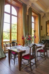 un comedor con una mesa con flores. en Kasteel Sterkenburg, en Driebergen