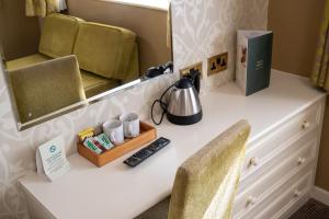 a desk with a mirror and two chairs and a sink at Millers Hotel by Greene King Inns in Sibson