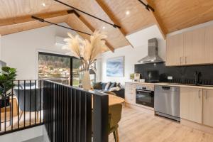 une cuisine ouverte et un salon avec des plafonds en bois dans l'établissement Modern Central Living - 3 Bed Aprtmnt with Gym, à Queenstown