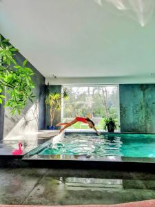 a person jumping into a pool in a house at La Casa nel Parco luxury b&b in San Lazzaro di Savena
