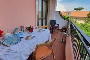 een tafel op een balkon met een witte tafellaken bij La Butterfly in Torre del Lago Puccini