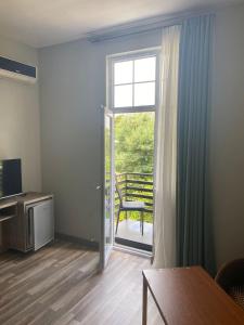 a living room with a door open to a balcony at Hotel Amigo II in Kobuleti