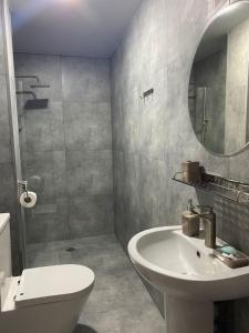 y baño con lavabo, aseo y espejo. en Hotel Amigo II, en Kobuleti