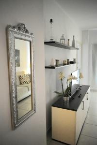 Cette chambre comprend un miroir et une table avec des fleurs. dans l'établissement bilocale Rachele, à Sestri Levante