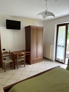 1 dormitorio con escritorio, armario y mesa en Locanda Fungo Reale 