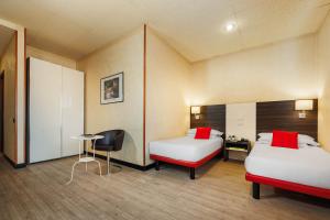 波隆那的住宿－JR Hotels Bologna Amadeus，一间设有两张床、一张桌子和一把椅子的房间