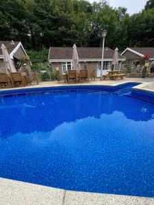 a blue swimming pool with chairs and a house at 14 Granite Henge in Looe