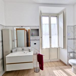 bagno bianco con lavandino e servizi igienici di Luminhouse Napoli a Napoli