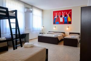 a room with two bunk beds and a ladder at Soleē, Family Holidays & Hostelling in Cesenatico