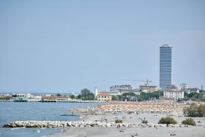 a beach with a lot of people and a building at Soleē, Family Holidays & Hostelling in Cesenatico