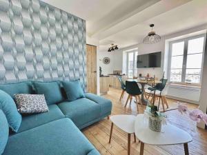 uma sala de estar com um sofá azul e uma mesa em Le Nid Douillet Cherbourgeois em Cherbourg en Cotentin
