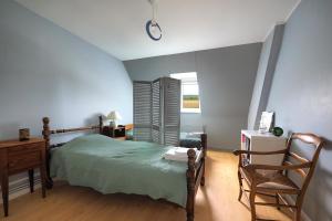 1 dormitorio con cama, escritorio y silla en La Mésangère, en Marcilly-sur-Eure