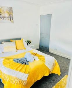 - une chambre avec un lit et une couverture jaune dans l'établissement MayDisc Long Stay Contractors Portsmouth Stays, à Portsmouth
