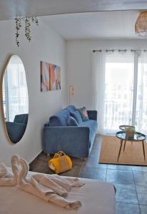 uma sala de estar com um sofá azul e um espelho em Cosy studio à 2 pas de la plage em Nice