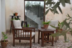 ein Wohnzimmer mit 2 Stühlen und einem Tisch mit Pflanzen in der Unterkunft Hotel La Vera Cruz in Caravaca de la Cruz