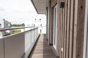 a balcony of a building with a wooden walkway at Katamaran in Olpenitz