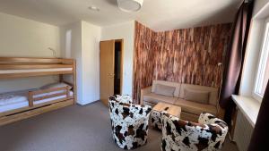 une chambre avec deux chaises, un lit et un canapé dans l'établissement Hotel Silberfelsen, à Menzenschwand