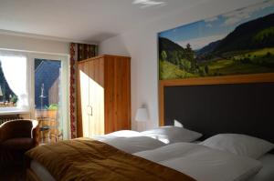 - une chambre avec un lit et une peinture murale dans l'établissement Hotel Silberfelsen, à Menzenschwand