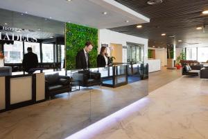 JR Hotels Bologna Amadeus في بولونيا: شخصين واقفين في بهو مبنى