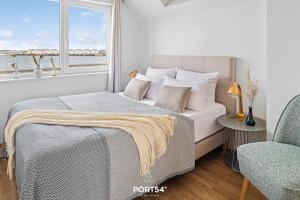 a bedroom with a bed and a window and a chair at Meerhaus 18 in Olpenitz