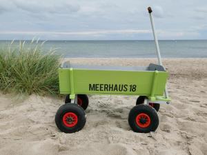a green wagon on the beach with the words mermaids at Meerhaus 18 in Olpenitz