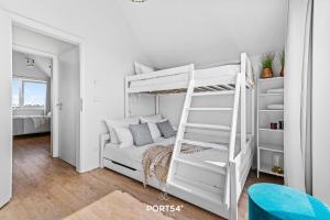 a white bunk bed with a ladder in a room at Meerhaus 18 in Olpenitz +21 photos