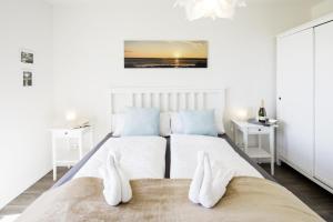 a bedroom with two beds with white and blue pillows at Ostseeliebe in Olpenitz