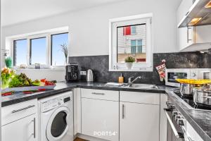 a kitchen with white cabinets and a dishwasher at SeaDream in Olpenitz