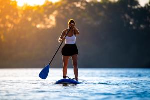 a woman on a paddle board in the water at Lütthoorn in Olpenitz