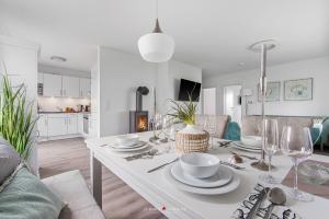 a white dining room table with plates and wine glasses at Blue Heaven in Olpenitz