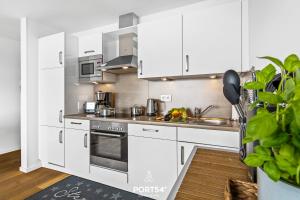 una cucina con armadietti bianchi ed elettrodomestici in acciaio inossidabile di Marina Sunset East a Olpenitz