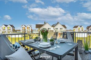 einen Tisch mit Tellern und Gläsern auf dem Balkon in der Unterkunft Port Seven in Olpenitz