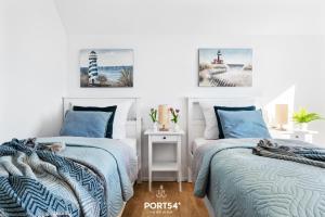 two beds in a bedroom with blue and white at Port Seven in Olpenitz