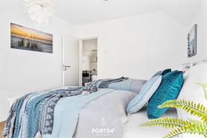ein Schlafzimmer mit einem Bett mit blauen Kissen darauf in der Unterkunft Port Seven in Olpenitz