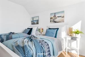 1 dormitorio con paredes blancas y 1 cama con sábanas azules en Port Seven en Olpenitz