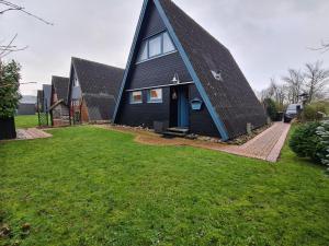 a large black house with a gambrel roof at Nordwind in Damp