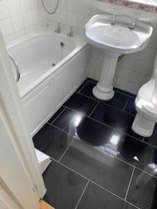 ein Badezimmer mit einem Waschbecken, einer Badewanne und einem WC in der Unterkunft 3 Bedrooms spacious house in Calcot , Reading in Tilehurst