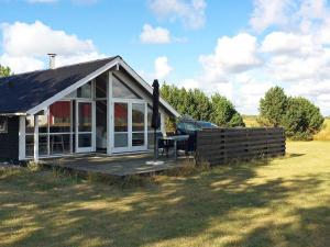 una pequeña casa con porche y una mesa en la cubierta en 6 person holiday home in Snedsted en Stenbjerg