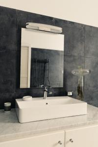 a bathroom with a white sink and a mirror at FONDO MONDELLO in Mondello
