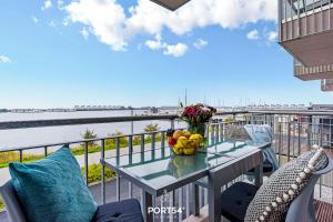 a table on a balcony with a view of the water at Hafenmelodie in Olpenitz
