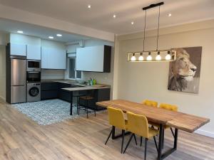 a kitchen and dining room with a wooden table and chairs at Soleado - En el centro de Gijón in Gijón