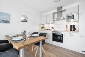 a kitchen with a wooden table in a room at Marina Sunrise in Olpenitz
